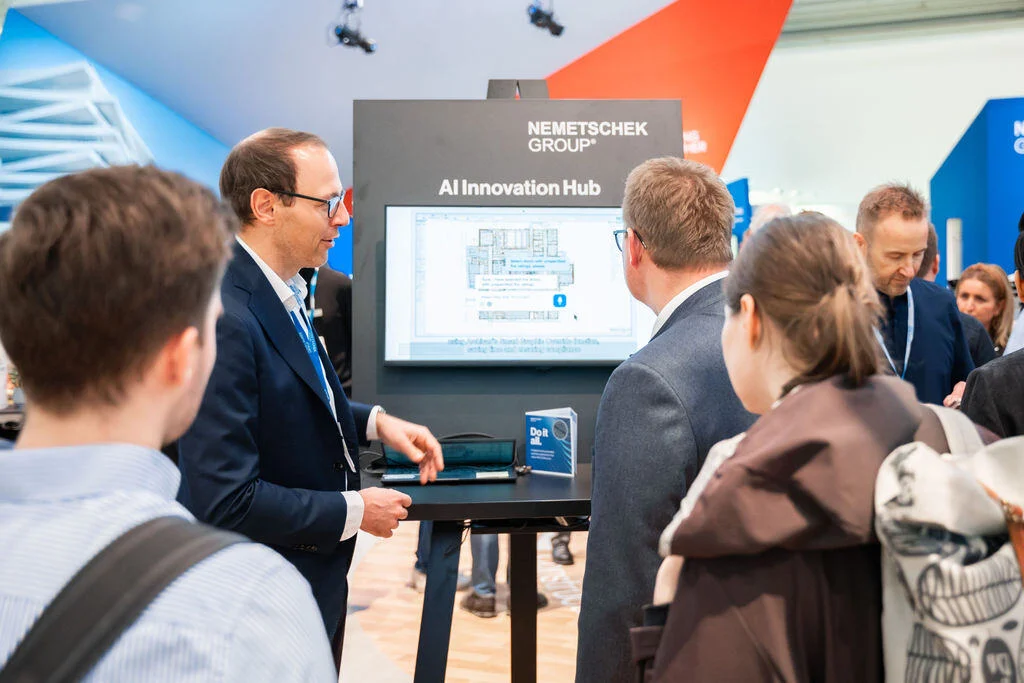 Julian Geiger, VP, Head of AI Product and Transformation at Nemetschek, showing the AI Assistant to visitors at BAU 2025 in Munich.